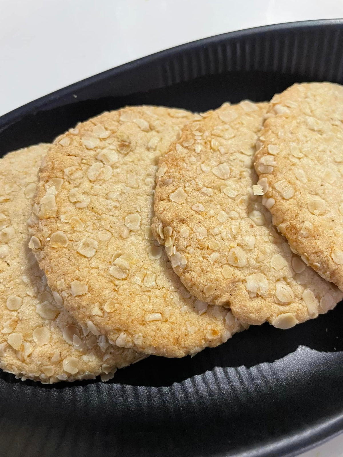 Close-up of oats cookies with oat topping on a black tray