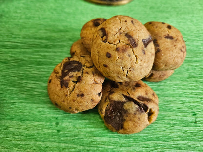 Chocolate chunk cookies with chocolate chunks stacked on a green background