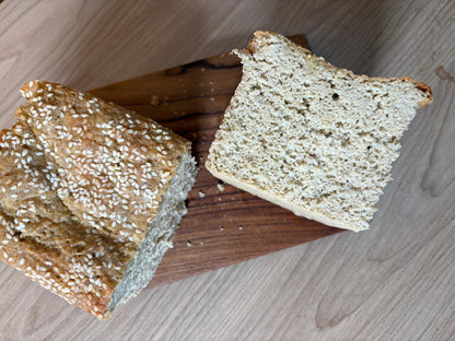 Whole jowar bread cut open showing the crumb, with sesame seeds