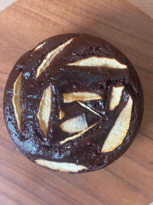 Close-up of dark chocolate apple cake decorated with apple slices