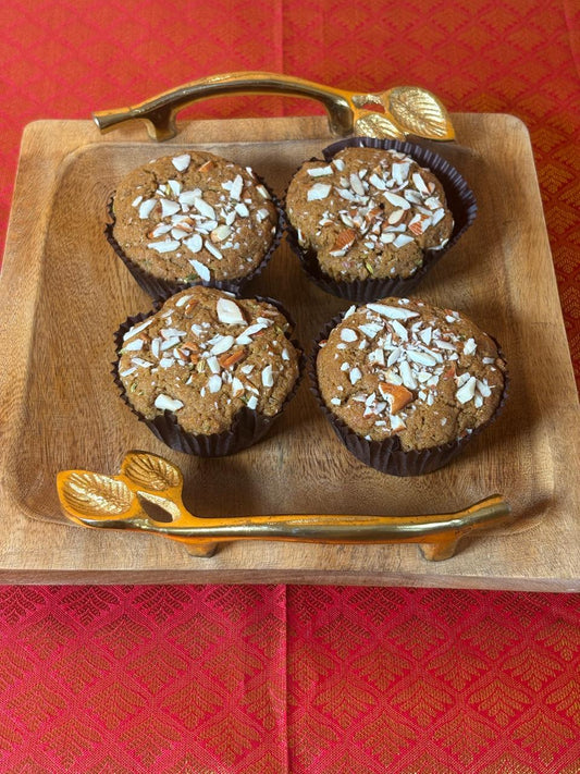 malpua muffins topped with almond flakes on a wooden tray