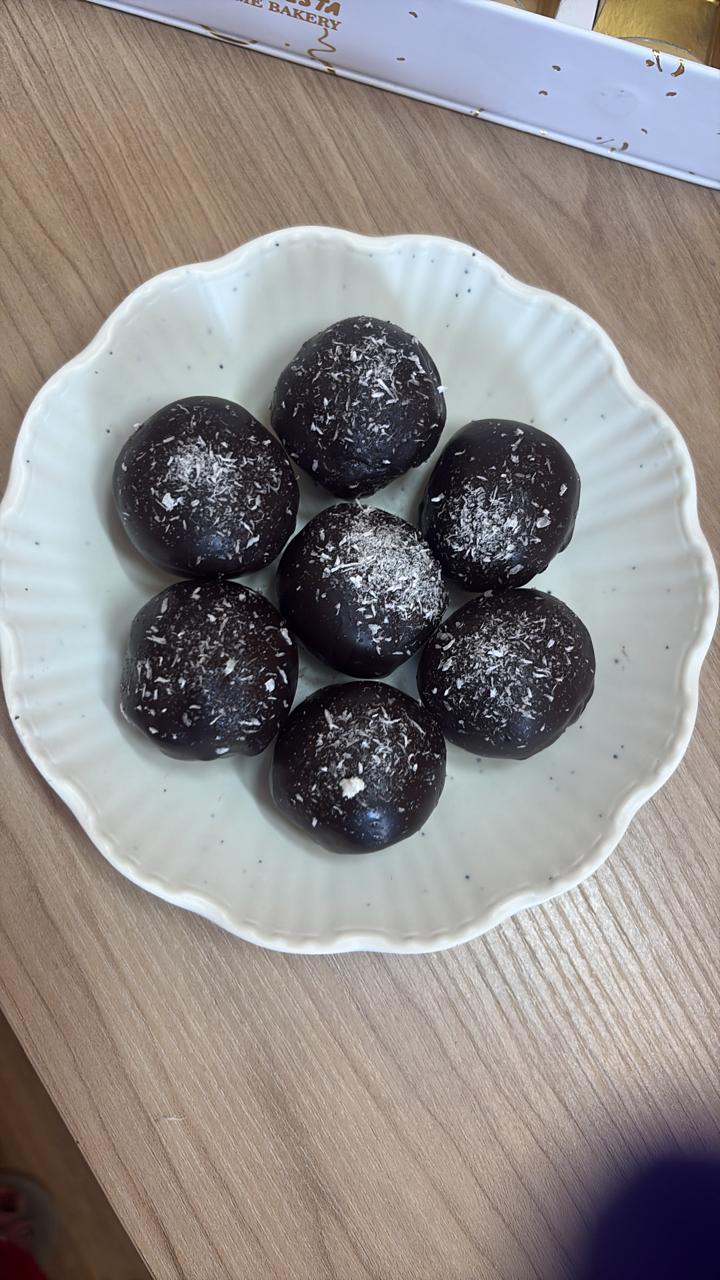 Dark chocolate energy balls with walnuts, figs and dates in a white bowl
