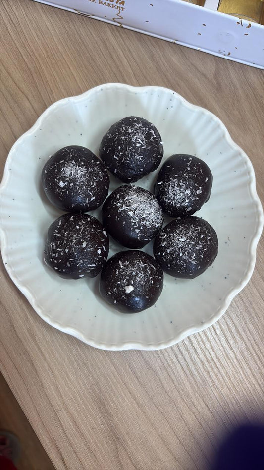 Dark chocolate energy balls with walnuts, figs and dates in a white bowl