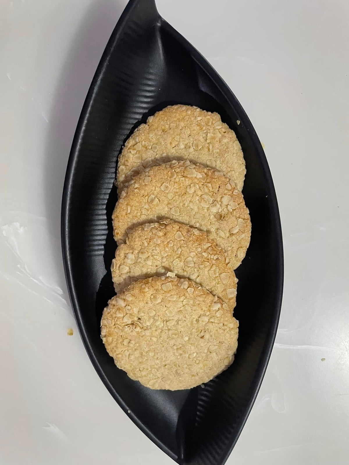 oats cookies on a black leaf-shaped tray